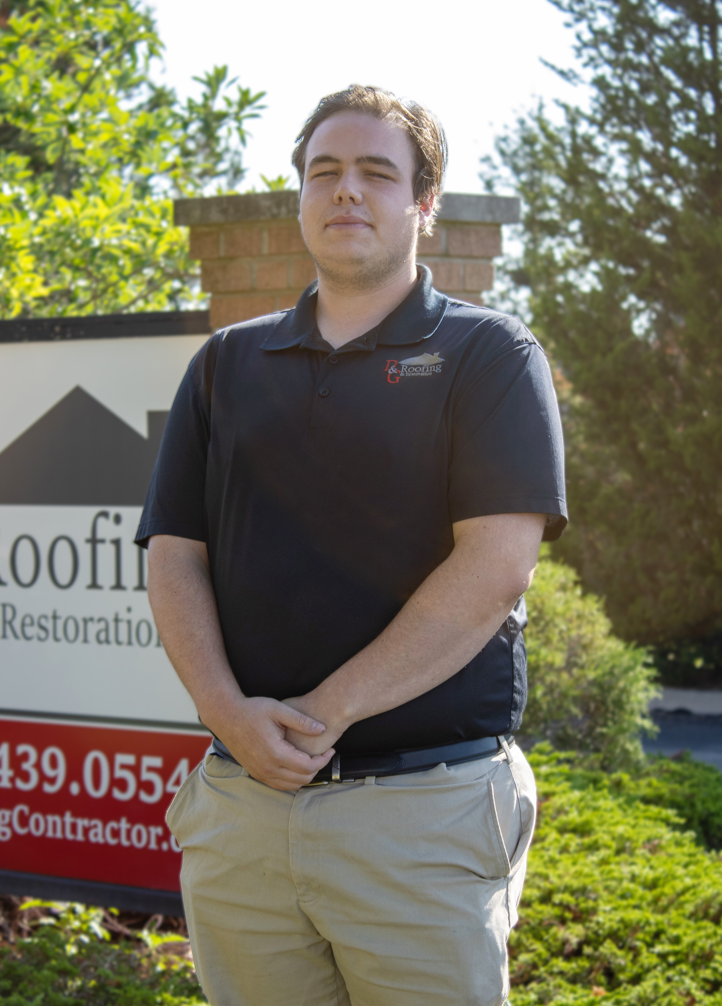 Team photo of Gabe Gaddis standing in front of the D&G monument sign