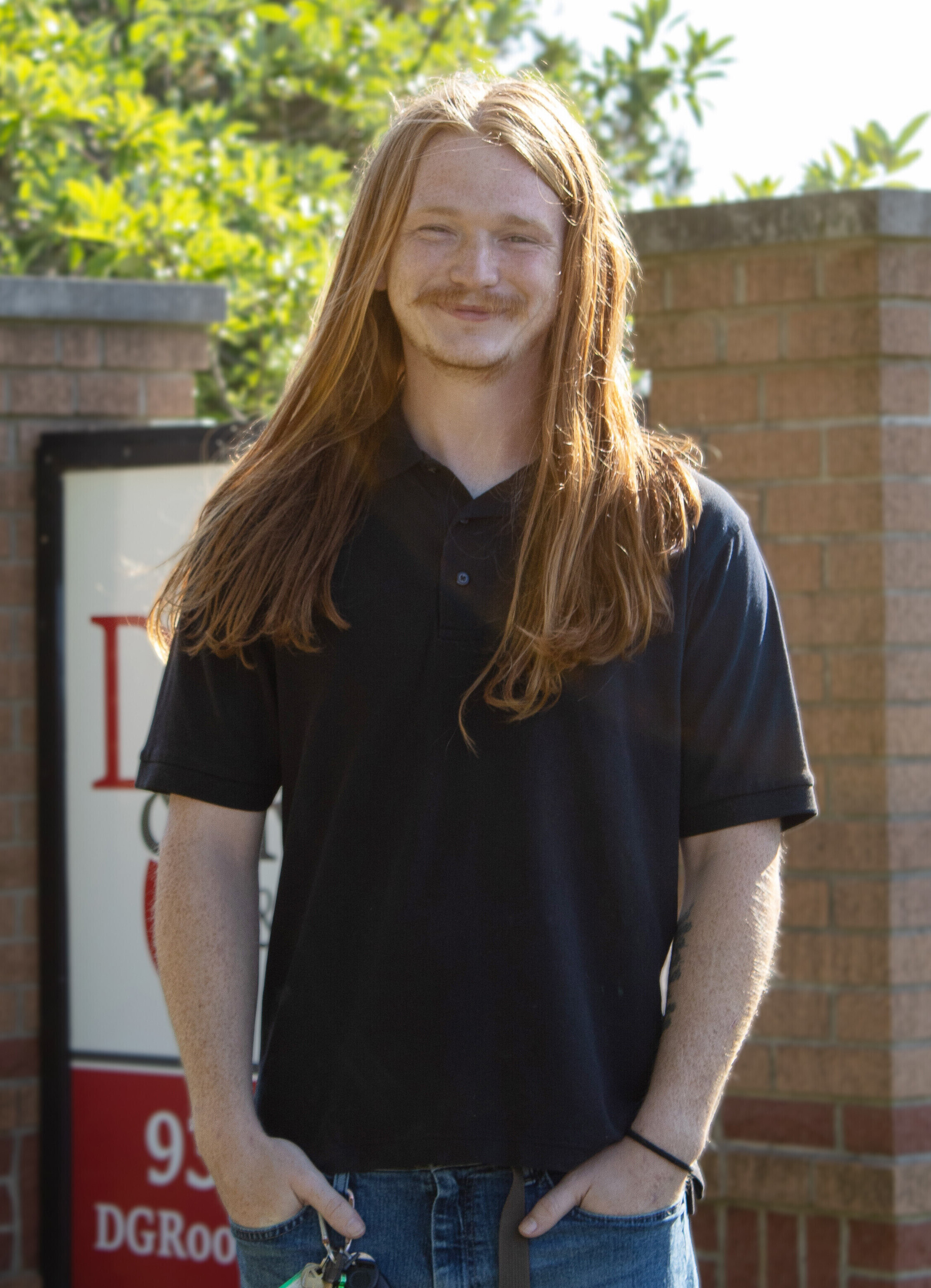 Photo of Reice Dooley standing in front of D&G's monument sign